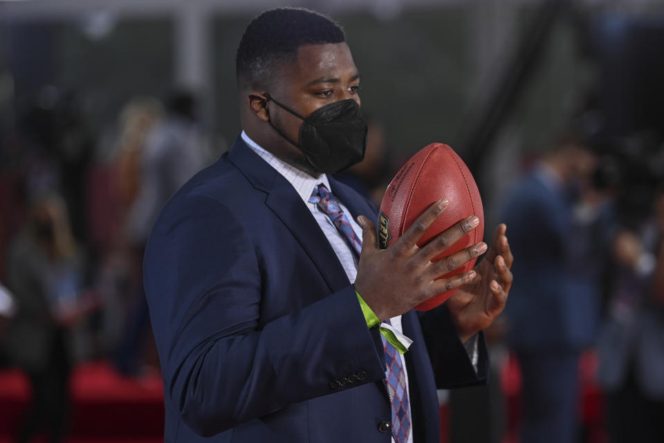 Alabama defensive lineman Christian Barmore holds a football as he appears on the Red Carpet at the Rock & Roll Hall of Fame before the NFL football draft, Thursday, April 29, 2021, in Cleveland. (AP Photo/David Dermer, Pool)