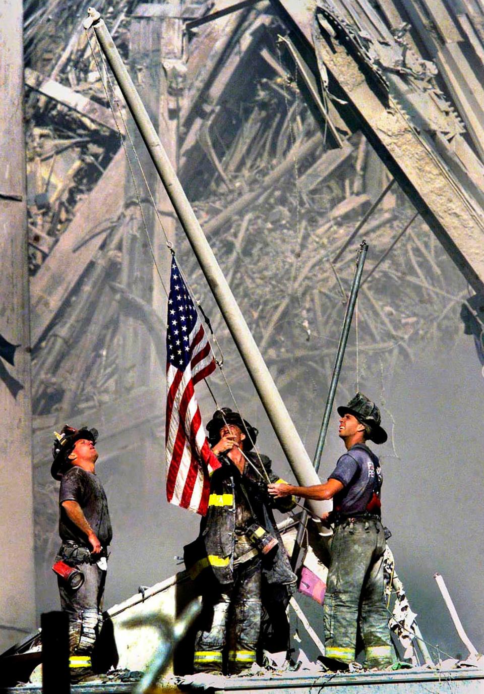 NYC firemen raise the American flag at Ground Zero after the terrorist attacks on the World Trade Center, taken on September 11th, 2001.