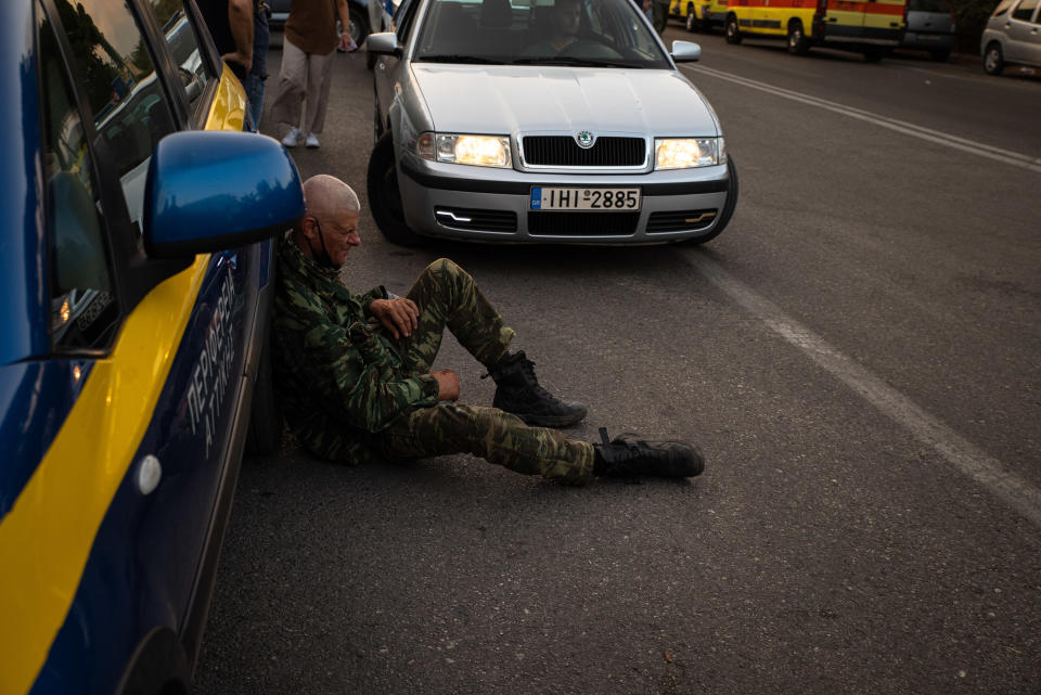 A volunteer sits against a vehicle as they take a break