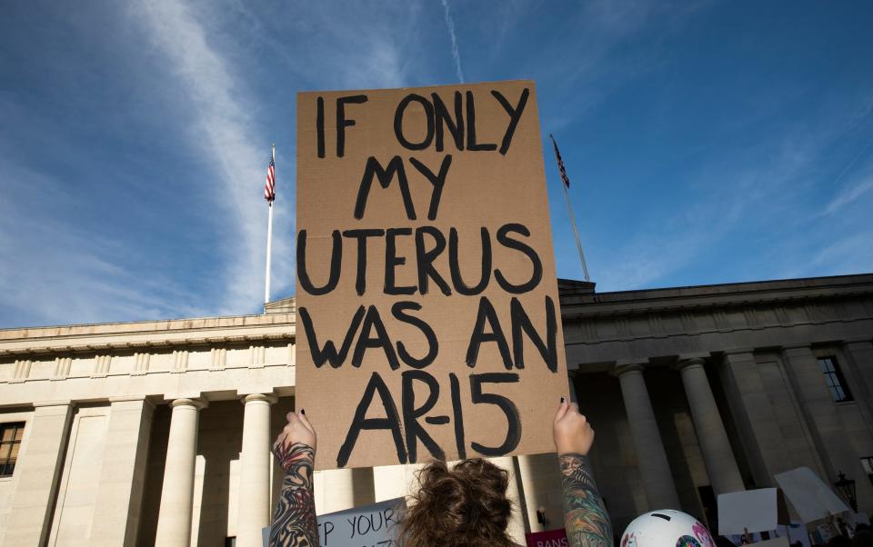 Zoe Benedict holds up a handmade sign during a rally at the Ohio Statehouse Friday, June 24, 2022, following the overturning of Roe v. Wade.