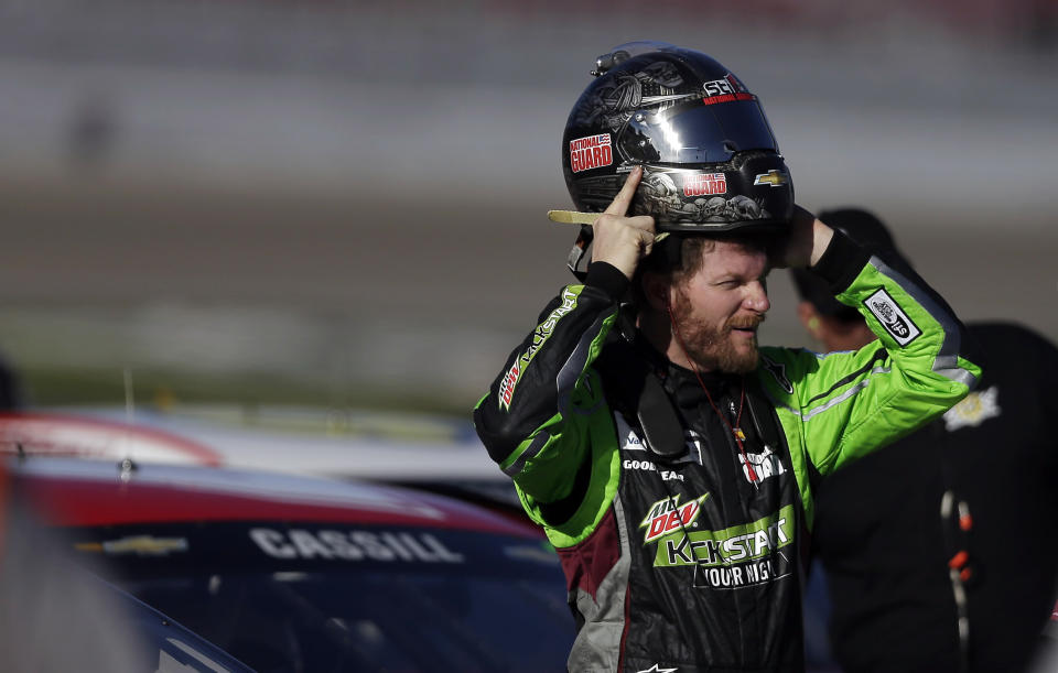 Dale Earnhardt Jr. puts on his helmet during qualifying for Sunday's NASCAR Sprint Cup Series auto race on Friday, March 7, 2014, in Las Vegas. (AP Photo/Isaac Brekken)