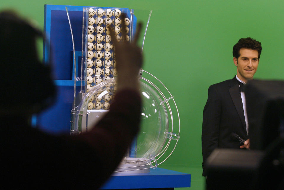 Powerball on-air talent Sam Arlen, right, is given a countdown before the start of the drawing at the Florida Lottery on Wednesday, Nov. 28, 2012, in Tallahassee, Fla. The numbers drawn in the $579.9-million game were: 5, 16, 22, 23, 29 and Powerball of 6. (AP Photo/Phil Sears)