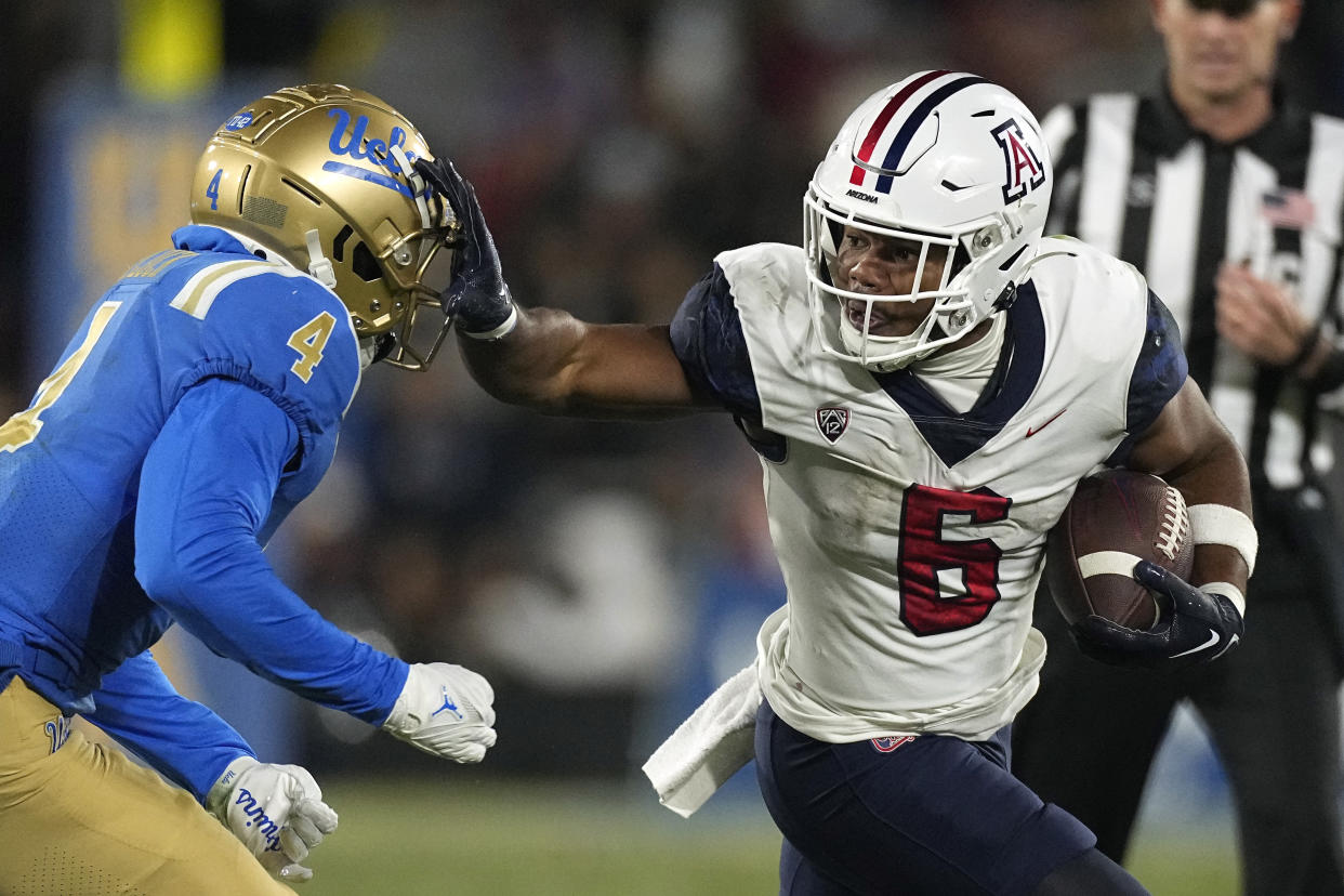 Arizona running back Michael Wiley, right, fends off UCLA defensive back Stephan Blaylock on Saturday, Nov. 12, 2022, in Pasadena, Calif. (AP Photo/Mark J. Terrill)