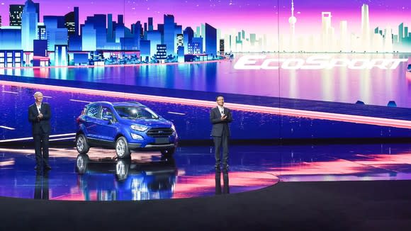 Two Ford executives standing next to the new EcoSport on stage.