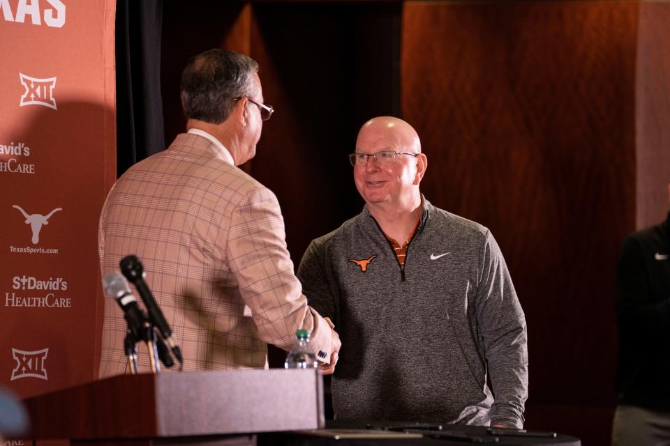 New Texas men's swimming coach and UT's director of swimming and diving Bob Bowman, right, greets Texas athletic director Chris Del Conte on Tuesday ahead of Bowman's introductory press conference. Bowman is replacing the retiring Eddie Reese.