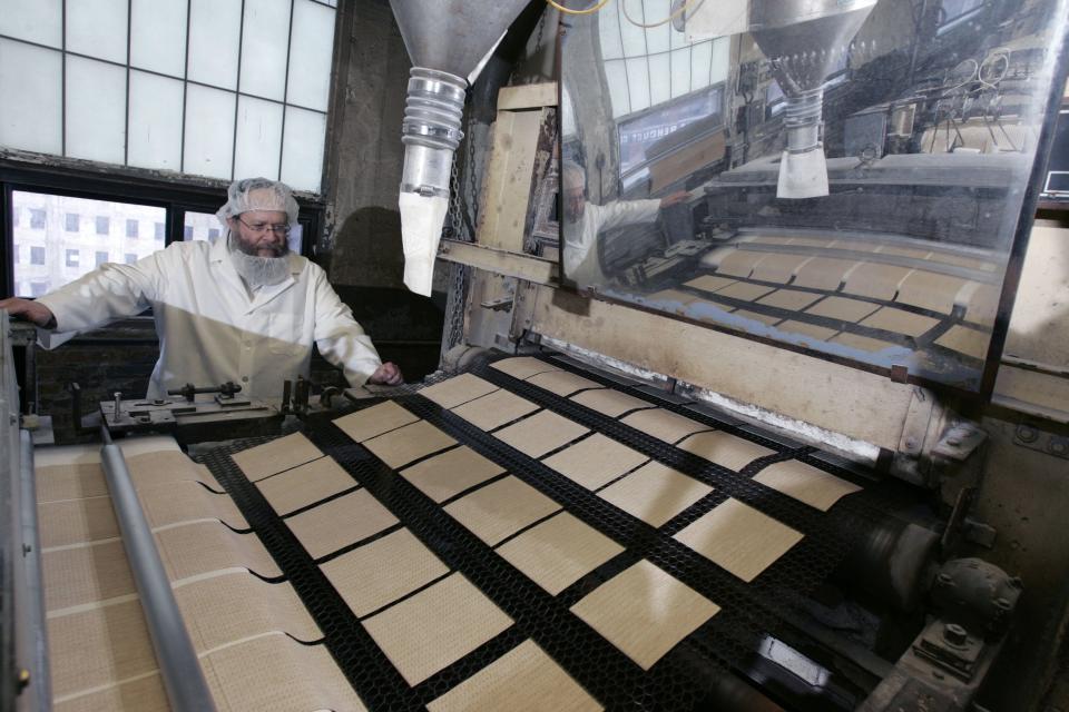 Rabbi Yaakov Horowitz, who oversees matzo production at the Manischewitz factory in New jersey, watches as uncooked matzo is moved along into the oven at the plant on March 5, 2007. Matzo is the unleavened bread product eaten by Jews around the world during the eight-day Passover holiday.