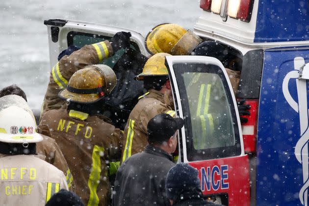 Emergency personnel tend to the person pulled from the submerged vehicle. (Photo: Jeffrey T. Barnes via AP)