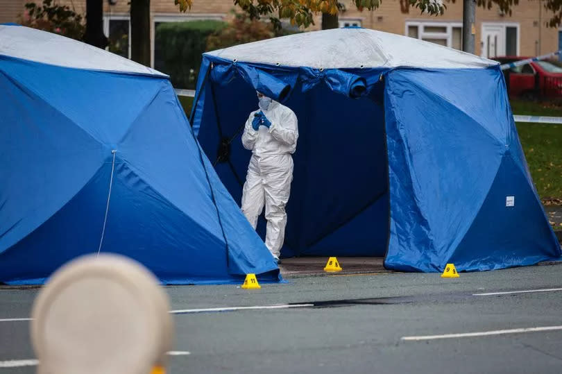 Police and forensic officers on Moss Lane East -Credit:Manchester Evening News