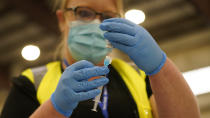 Registered nurse Lindsey Meyer prepares to administer the COVID-19 vaccine at the Davis County Legacy Center Tuesday, Jan. 12, 2021, in Farmington, Utah. Utah began vaccinating teachers and school staff across the state. They are aiming to have all teachers and school staff vaccinated by the end of February. (AP Photo/Rick Bowmer)