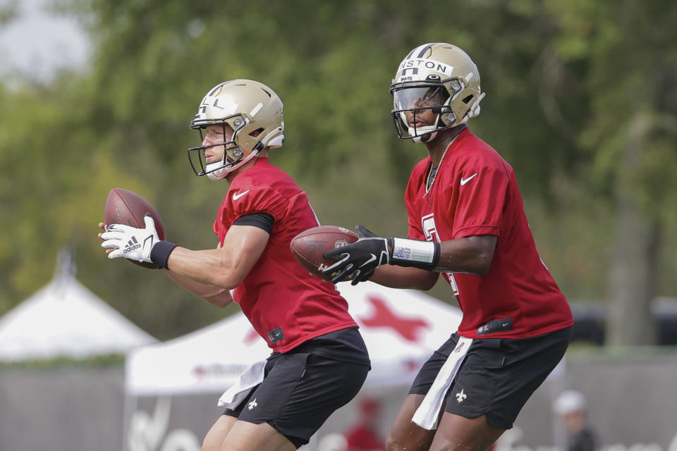 New Orleans Saints quarterback Jameis Winston (2) and quarterback Taysom Hill (7) take snaps during NFL football training camp in Metairie, Friday, July 30, 2021. (AP Photo/Derick Hingle)