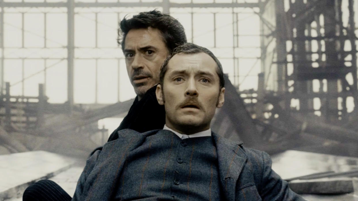  Jude Law and Robert Downey Jr sitting in shock in Sherlock Holmes. 