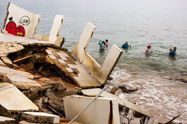 People swim by the ruins of a structure damaged during Hurricane María. (Photo: Erika P. Rodriguez for HuffPost)