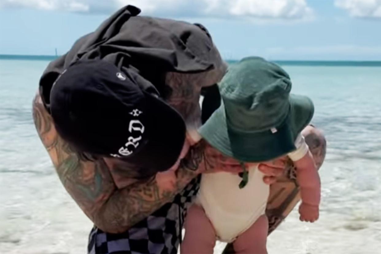<p>Travis Barker/Instagram</p> Travis Barker poses with son Rocky on the beach