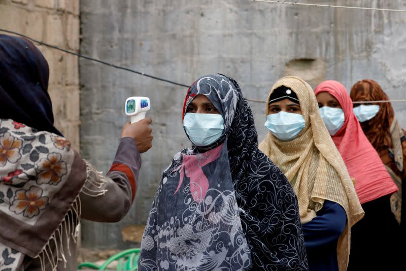 FILE PHOTO: Vaccinators get their temperature checked during an anti-polio campaign in Karachi