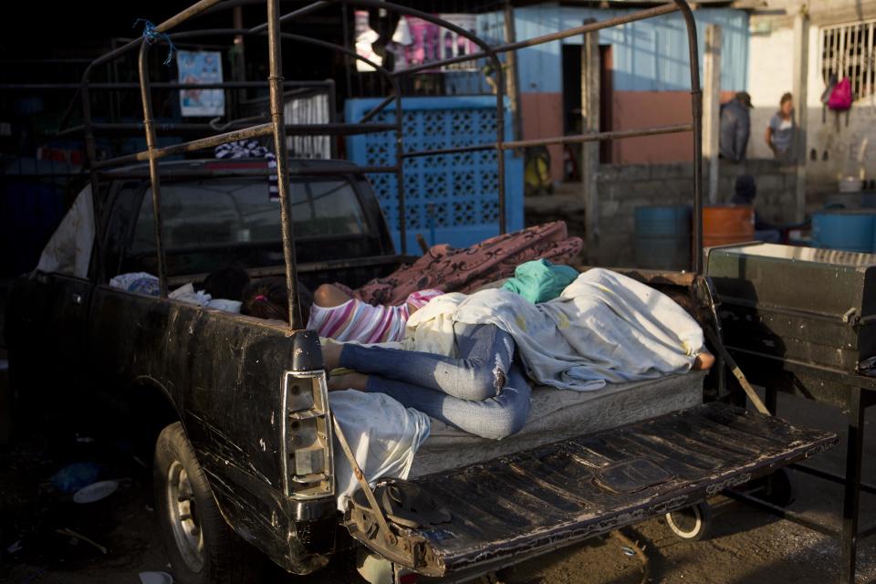 People lie on a mattress in a truck bed outside their home after several earthquakes in Managua, Nicaragua, Monday, April 14, 2014. The government is recommending people sleep outside after an earthquake occurred a bit further away from Managua Sunday morning, following quakes on Thursday and Friday. (AP Photo/Esteban Felix)