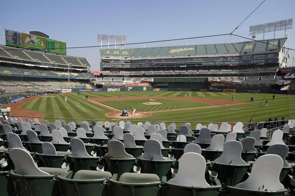 FILE - In this Sept. 30, 2020, file photo, cutouts are seated at Oakland Coliseum as Chicago White Sox's Dallas Keuchel, center, pitches to Oakland Athletics' Tommy La Stella during Game 2 of an American League wild-card baseball series in Oakland, Calif. California officials will allow people to attend Major League Baseball games and other sporting events, go to Disneyland and watch live performances in limited capacities starting April 1, 2021. The rules announced Friday, March 5, 2021, coincide with baseball's opening day. The San Diego Padres, Los Angeles Angels and Oakland Athletics all have home games scheduled for April 1. (AP Photo/Eric Risberg, File)