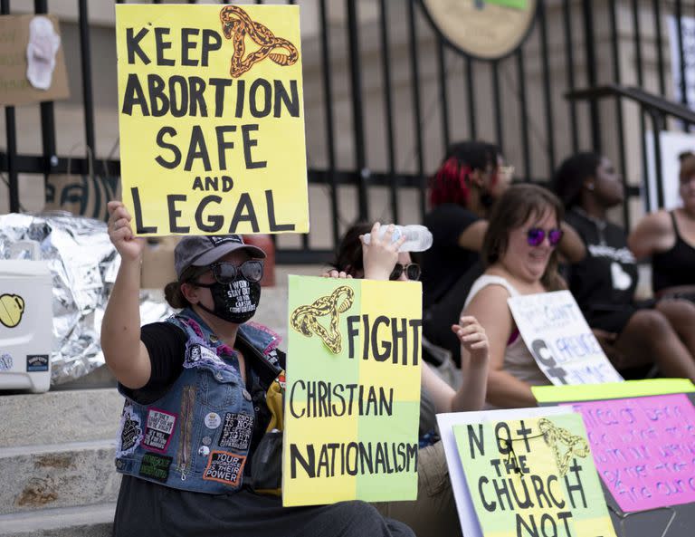 Un pequeño grupo, entre los que se encuentra Stephanie Batchelor, a la izquierda, se sienta en las escaleras del Capitolio del Estado de Georgia para protestar por la anulación de Roe v. Wade el domingo 26 de junio de 2022.