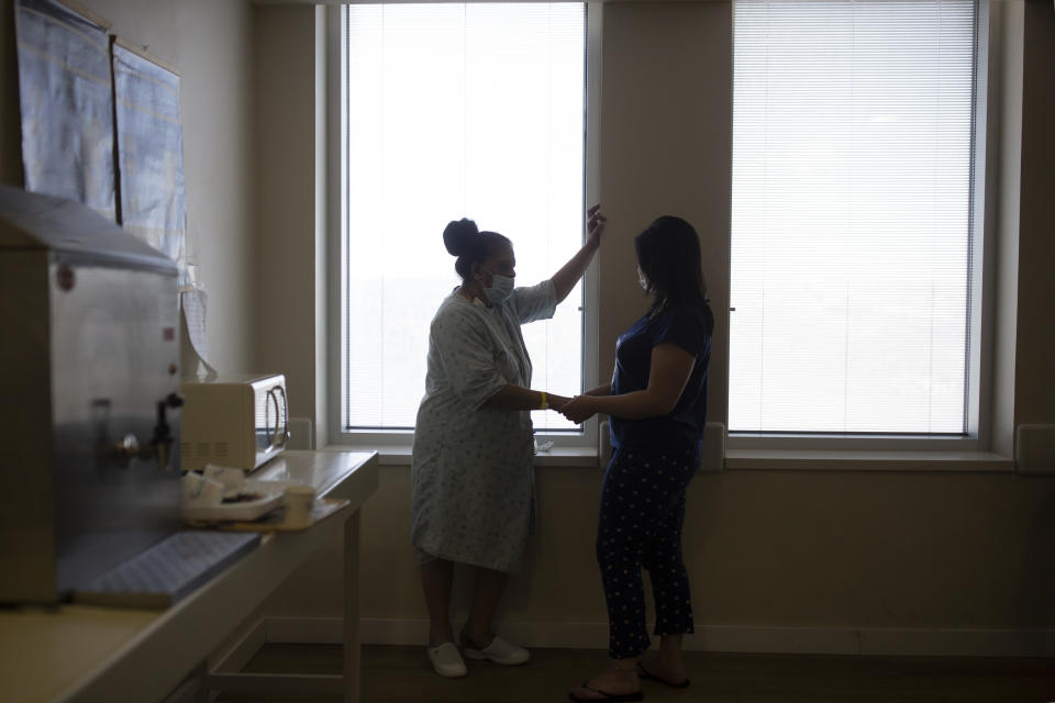 Randa Aweis, left, who received a kidney transplant from Yigal Yehoshua, a Jewish man who died May 17 after being pelted with rocks amid clashes between Arabs and Jews in Israel’s mixed city of Lod, speaks with her daughter, Nevine at Hadassah Ein Karem Hospital in Jerusalem, Monday, May 24, 2021. (AP Photo/Maya Alleruzzo)