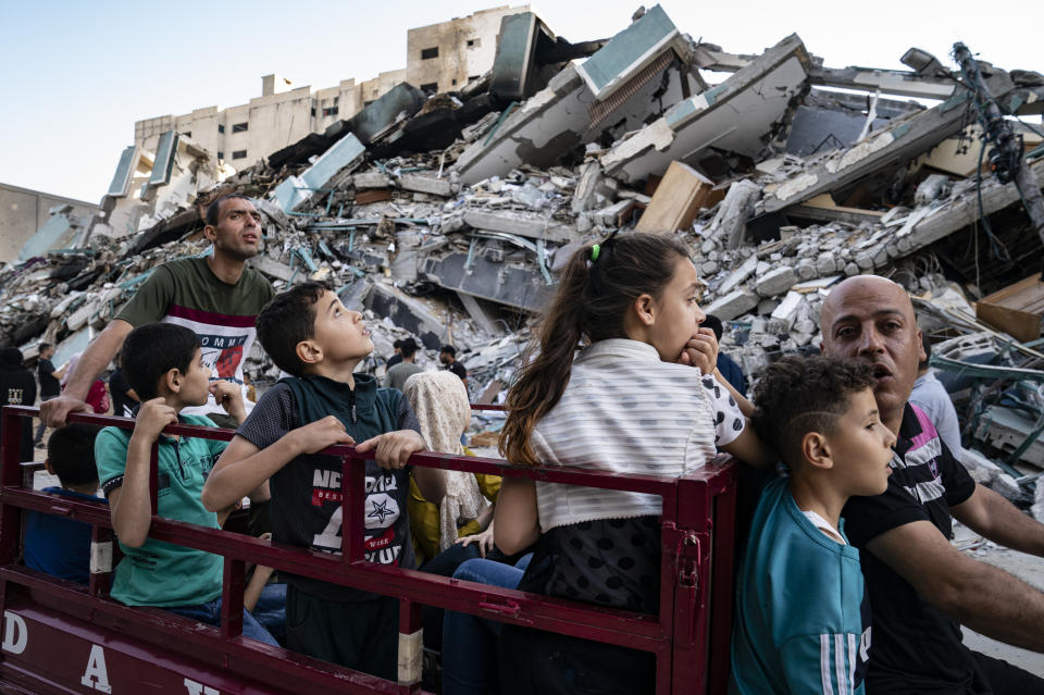 Spectators gather to view the rubble of the al-Jalaa building following a cease-fire reached after an 11-day war between Gaza's Hamas rulers and Israel, in Gaza City, Friday, May 21, 2021. The building housed the Associated Press bureau in Gaza City for 15 years. (AP Photo/John Minchillo)