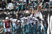 Fans celebrate with Jacksonville Jaguars players after wide receiver Jamal Agnew ran back an Arizona Cardinals missed field goal for a 109-yard touchdown return during the first half of an NFL football game, Sunday, Sept. 26, 2021, in Jacksonville, Fla. (AP Photo/Phelan M. Ebenhack)