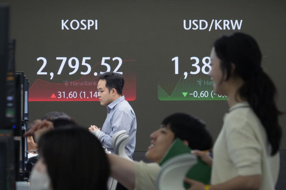 Currency traders watch monitors near the screen showing the Korea Composite Stock Price Index (KOSPI), left, and the foreign exchange rate between U.S. dollar and South Korean won at the foreign exchange dealing room of the KEB Hana Bank headquarters in Seoul, South Korea, Wednesday, June 19, 2024. (AP Photo/Ahn Young-joon)