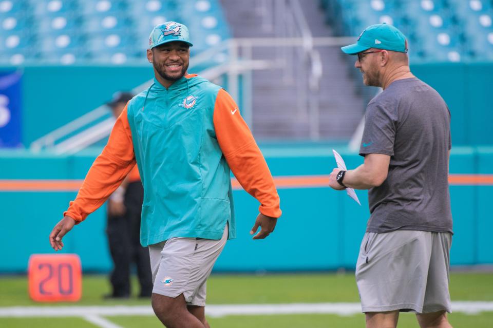 Miami Dolphins quarterback Tua Tagovailoa (1) smiles while speaking with Dolphins quarterback coach Darrell Bevell before the start of the game between host Miami Dolphins and the Houston Texans at Hard Rock Stadium on Sunday, November 27, 2022, in Miami Gardens, FL.