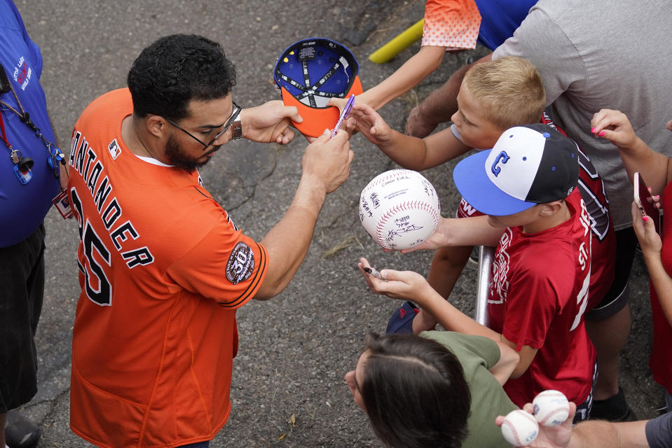 Baltimore Orioles' Anthony Santander, left, gives autographs as he arrives for a visit to the Little League World Series in South Williamsport, Pa., Sunday, Aug. 21, 2022. The Orioles play the Boston Red Sox in the Little League Classic on Sunday Night Baseball. (AP Photo/Gene J. Puskar)