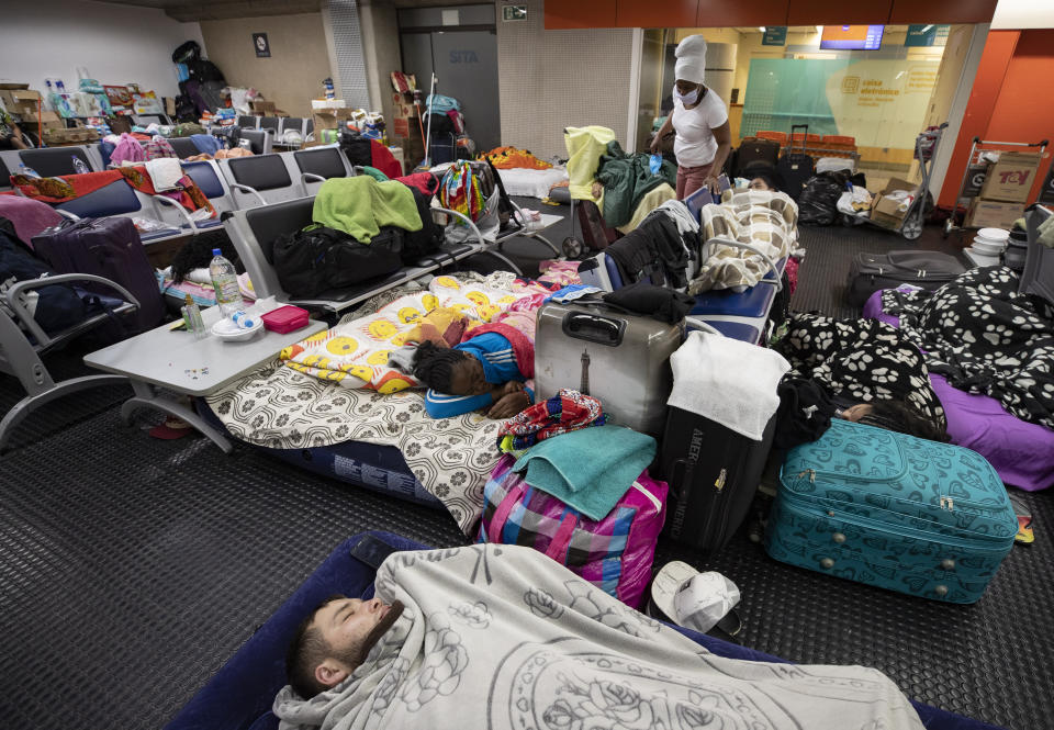 Stranded Colombians sleep inside the Sao Paulo international airport while flights are severely limited during the COVID-19 pandemic in Guarulhos, Brazil, Wednesday, May 27, 2020. Hundreds of people, including migrants and tourists, have been living inside the airport, waiting for humanitarian flights to leave Brazil. (AP Photo/Andre Penner)