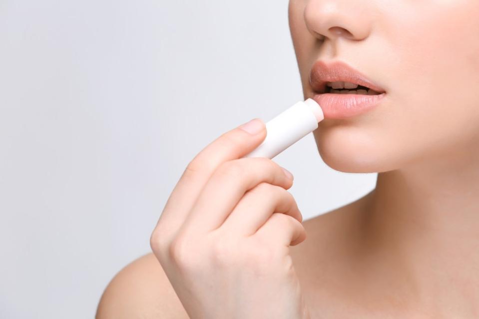 While lip balms seal in moisture for a moisturized pout, added flavors, fragrance and color can cause further irritation. Africa Studio – stock.adobe.com