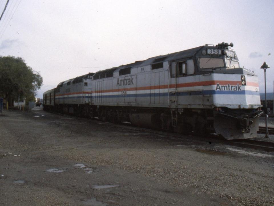 silver amtrak train on tracks from 1984