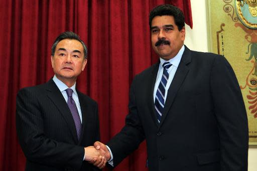 El presidente de Venezuela, Nicolás Maduro, junto al canciller de China, Wang Yi, en un encuentro en el palacio de Miraflores de Caracas, el 21 de abril de 2014. (PRESIDENCIA/AFP | --)