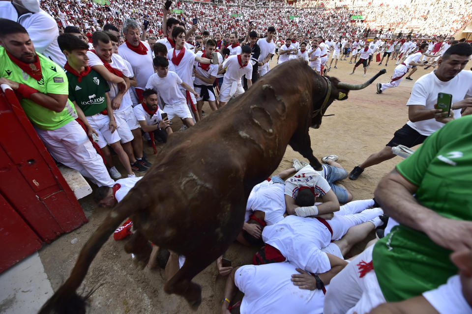 A fighting bull jumps over runners entering the bullring during the running of the bulls at the San Fermin Festival in Pamplona, northern Spain, Tuesday, July 12, 2022. Revellers from around the world flock to Pamplona every year for nine days of uninterrupted partying in Pamplona's famed running of the bulls festival which was suspended for the past two years because of the coronavirus pandemic. (AP Photo/Alvaro Barrientos)