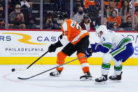 Philadelphia Flyers' James van Riemsdyk, left, tries to get past Vancouver Canucks' Jack Rathbone during the second period of an NHL hockey game, Friday, Oct. 15, 2021, in Philadelphia. (AP Photo/Matt Slocum)