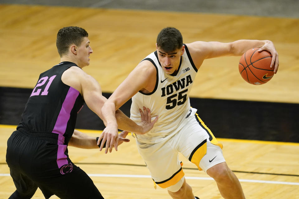 Iowa center Luka Garza drives past Penn State forward John Harrar, left, during the first half of an NCAA college basketball game, Sunday, Feb. 21, 2021, in Iowa City, Iowa. (AP Photo/Charlie Neibergall)