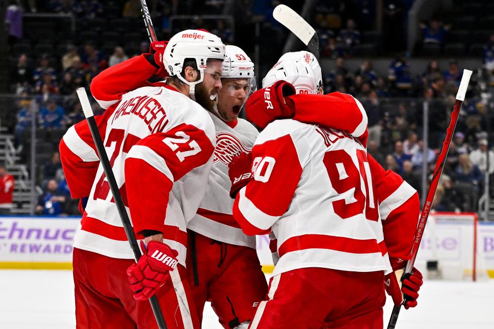 Red Wings center Michael Rasmussen (27) is congratulated by defenseman Moritz Seider and center Joe Veleno (90) after scoring during the third period of the Wings' 6-4 win on Tuesday, Dec. 12, 2023, in St. Louis.
