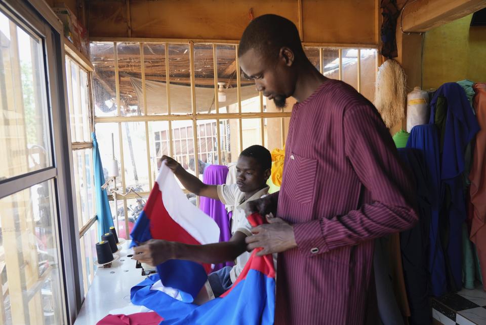 Seamsters make Russian flags in Niamey, Niger, Thursday, Aug. 24, 2023. Since the coup, Nigeriens have been waving Russian and Wagner flags at protests, fastening them to car windows and selling them in the streets. (AP Photo/Sam Mednick)