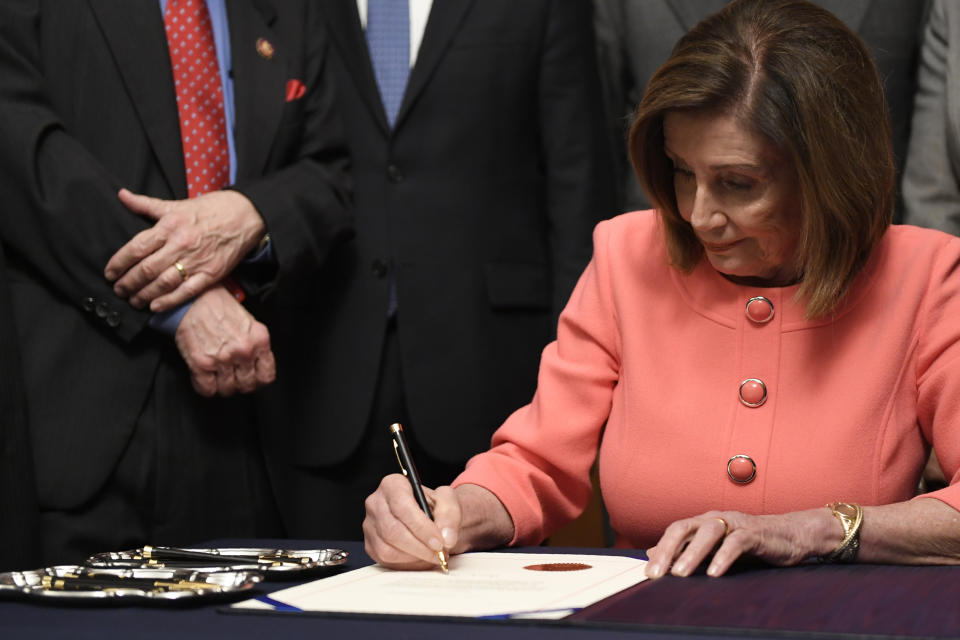 House Speaker Nancy Pelosi of Calif., signs the resolution to transmit the two articles of impeachment against President Donald Trump to the Senate for trial on Capitol Hill in Washington, Wednesday, Jan. 15, 2020. The two articles of impeachment against Trump are for abuse of power and obstruction of Congress. (AP Photo/Susan Walsh)