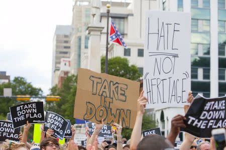 People hold signs during a protest asking for the removal of the confederate battle flag that flies at the South Carolina State House in Columbia, SC June 20, 2015. REUTERS/Jason Miczek TPX IMAGES OF THE DAY