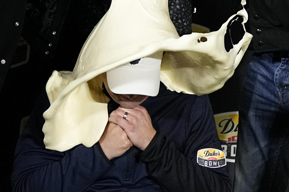 West Virginia head coach Neal Brown gets dunked with mayonnaise after their win against North Carolina in an NCAA college football game at the Duke's Mayo Bowl Wednesday, Dec. 27, 2023, in Charlotte, N.C. (AP Photo/Chris Carlson)