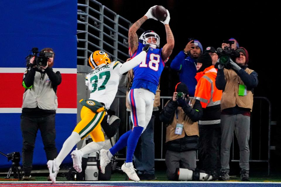 Dec 11, 2023; East Rutherford, New Jersey, USA; New York Giants wide receiver Isaiah Hodgins (18) catches a touchdown against Green Bay Packers cornerback Carrington Valentine (37) during the third quarter at MetLife Stadium. Mandatory Credit: Robert Deutsch-USA TODAY Sports