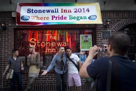 People pose for photos in front of the Stonewall Inn before the start of Pride Week activities in the Manhattan borough of New York June 27, 2014. REUTERS/Carlo Allegri