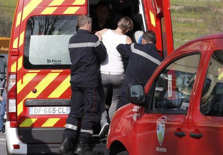 French firefighters evacuate a woman near the Tocqueville high school after a shooting incident injuring at least eight people, in Grasse, southern France, March 16, 2017. REUTERS/Eric Gaillard