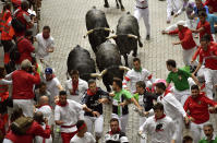 <p>Revellers run in front of Miura’s fighting bulls during the running of the bulls at the San Fermin Festival, in Pamplona, northern Spain, July 14, 2017. (Photo: Alvaro Barrientos/AP) </p>