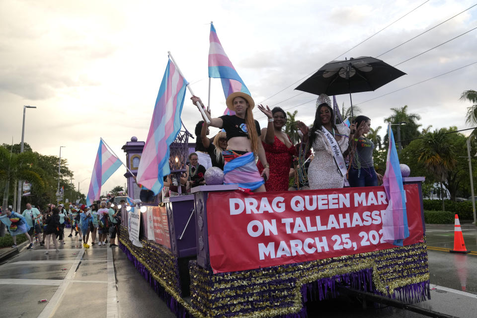 Tiffany Arieagus, a transgender woman, second from left, rides on a float during the Stonewall Pride Parade and Street Festival, Saturday, June 17, 2023, in Wilton Manors, Fla. Arieagus, 71, is an acclaimed drag performer in south Florida also works in social services for SunServe, an LGBTQ+ nonprofit. (AP Photo/Lynne Sladky)