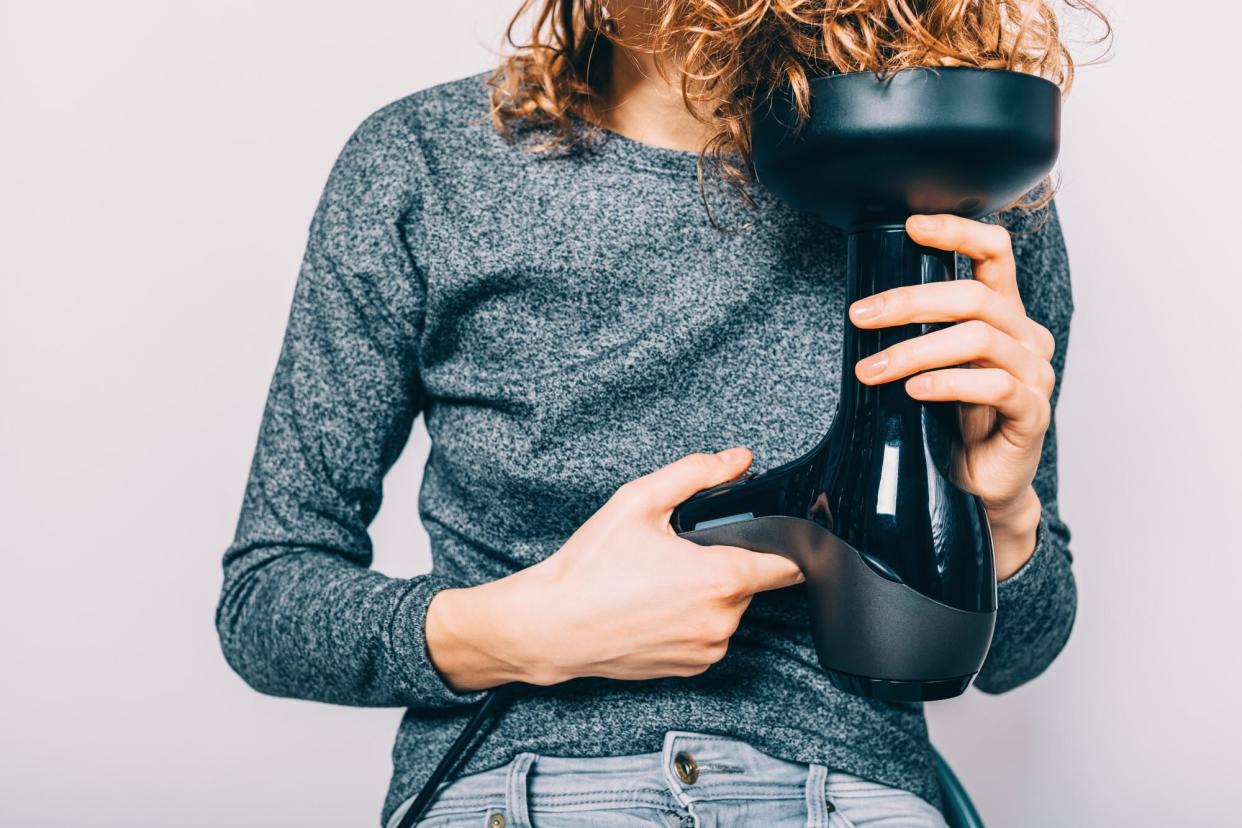 woman blow drying hair with diffuser