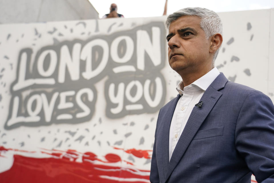 FILE - London Mayor Sadiq Khan stands in front of a mural as he attends a live screening of the Women's Euro 2022 semifinal soccer match between England and Sweden at the fan area in Trafalgar Square in London, England, Tuesday, July 26, 2022. The U.K.’s governing Conservative Party has suspended ties with one if its lawmakers after he accused London Mayor Sadiq Khan of being controlled by Islamists, as tensions over the Israel-Hamas war continue to roil British politics. (AP Photo/Albert Pezzali, File)