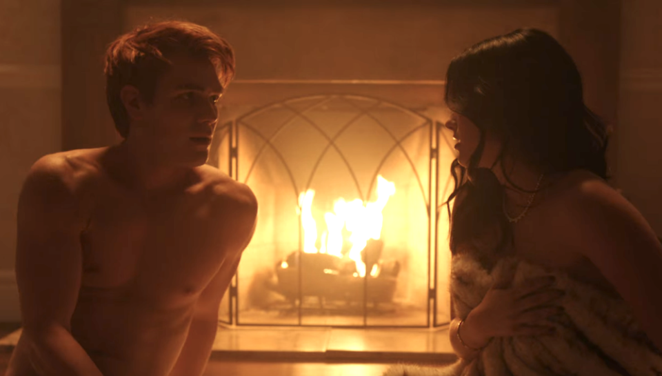 A man and a woman by a fireplace