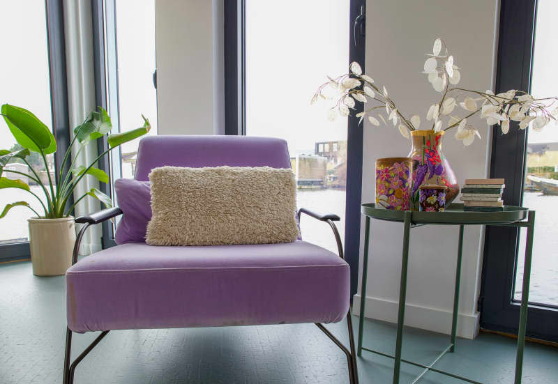 Purple chair and decor on side table in living room.