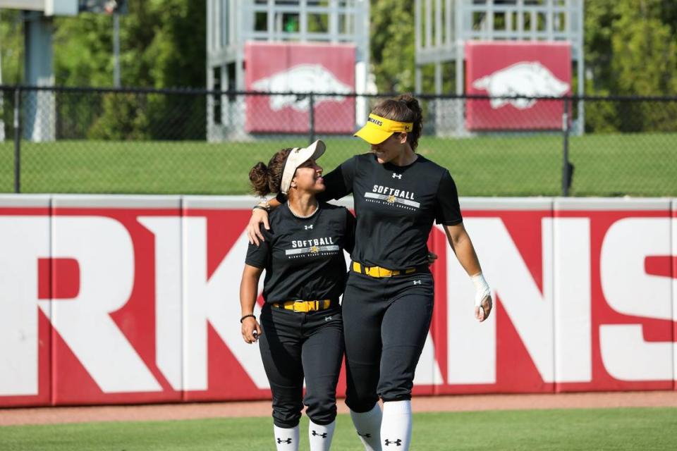 Madyson Espinosa walks off the field with former Wichita State softball teammate Neleigh Herring.