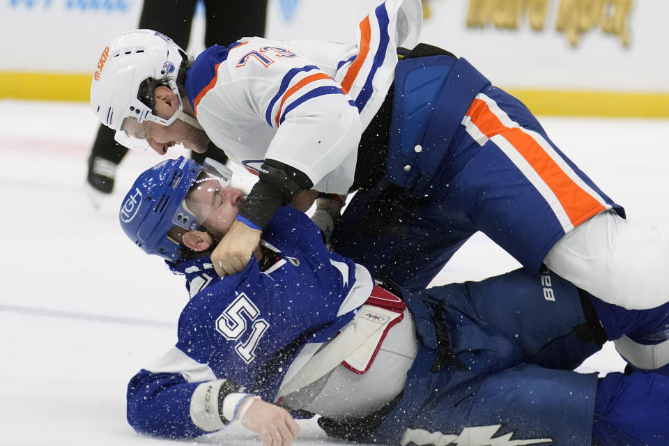 Edmonton Oilers defenseman Vincent Desharnais (73) and Tampa Bay Lightning left wing Austin Watson (51) fight during the first period of an NHL hockey game Saturday, Nov. 18, 2023, in Tampa, Fla. (AP Photo/Chris O'Meara)